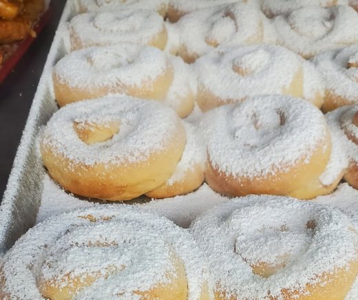 A tray of powdered-sugar mallorca pastries.